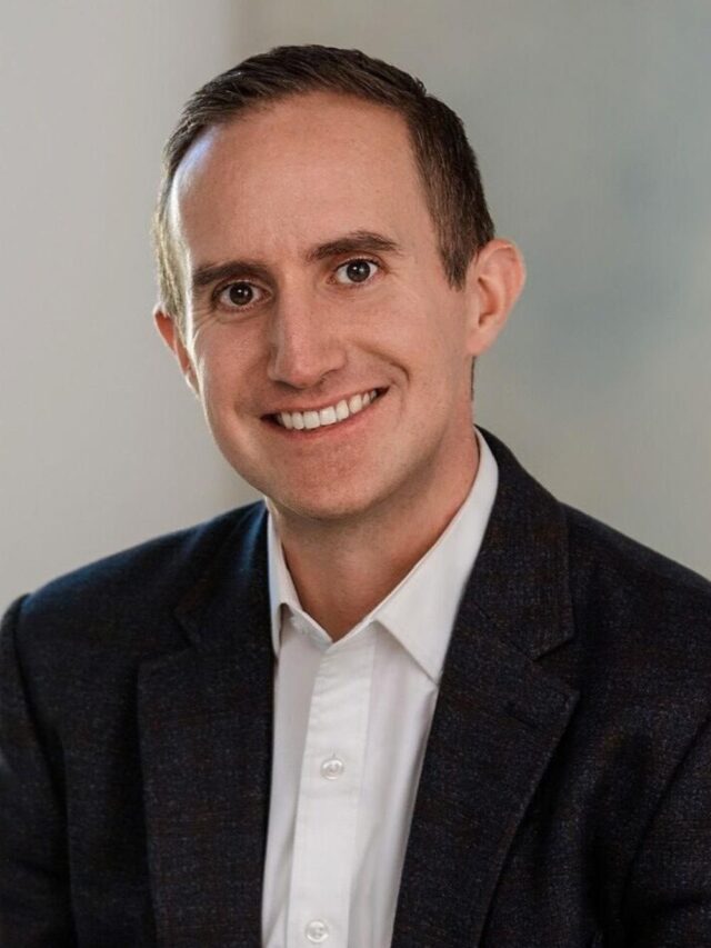 A headshot of Morgan Housel, smiling and looking directly at the camera.